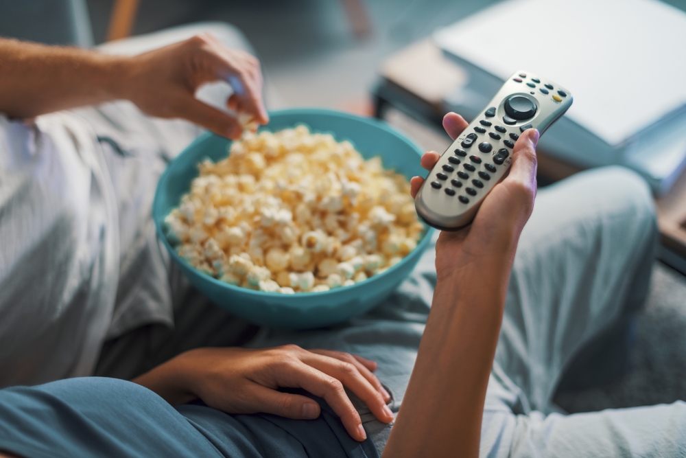 Couple,Sitting,On,The,Couch,And,Watching,Tv,,The,Woman